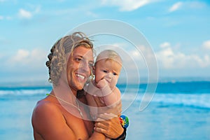 Young father, baby son walk, have fun on sea beach