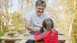 Young father building wooden playhouse with his son