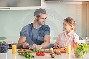 Young father and daughter cooking meal together