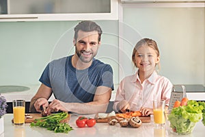 Young father and daughter cooking meal together