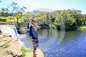 Young father with daughter on his shoulders enjoying Kerikeri waterfall