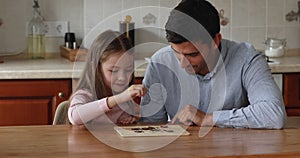 Young father and daughter play boardgame at home