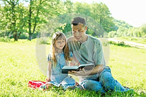 Young father with a  daughter reading the Bible