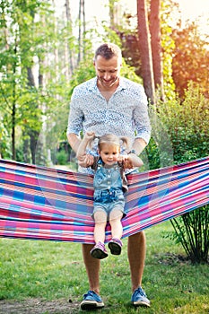 Young father with doughter having fun in hammock. Father`s day, family day, children`s day concept