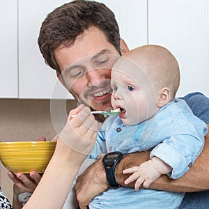 Young father enjoying his baby feeding