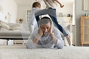 Shocked young dad tired of noisy active children photo