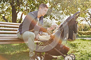 A young father feeds his young son a mixture of bottles