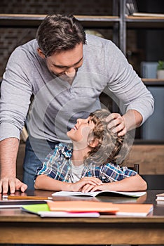 Son doing homework with father