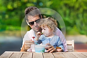 Young father and his baby daughter enjoying ice cream