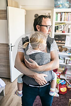 Young father with his daughter in baby carrier