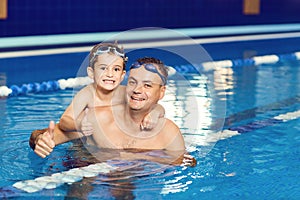 Young father and his little son in an indoor swimming pool.