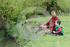 Young father and his son fishing together
