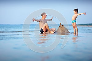 Young father and his son having fun at beach