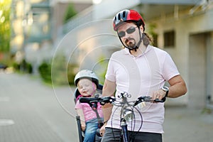 Young father and his toddler girl riding a bicycle