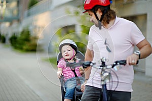 Young father and his toddler girl riding a bicycle