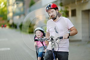 Young father and his toddler girl riding a bicycle