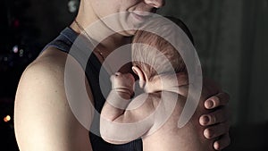 Young father holding his child in his arms and presses to his chest.