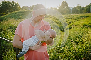 Young father holding his infant son. Caucasian man and 3 month old baby boy outdoors. Happy family, Father`s love concept.