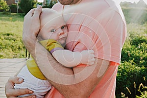Young father holding his infant son. Caucasian man and 3 month old baby boy outdoors. Happy family, Father`s love concept.