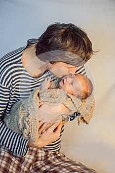 Young father holding his newborn baby son in his arms