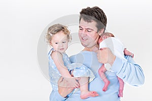 Young father holding toddler girl and newborn baby