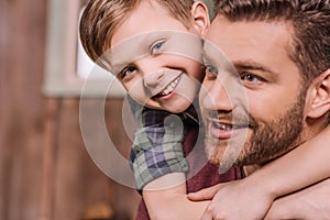 Young father with little son sitting on porch at backyard