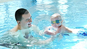 Young father with little son swimming in pool