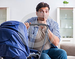 Young father looking after newborn baby at home