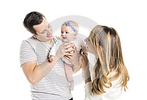 Young father, mother holding cute baby girl over white background