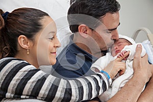 Young father and mother with their newborn baby girl at the hospital on the day of her birth. Family concept. Parenthood concept