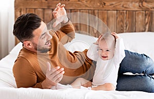 Young Father Playing With Little Baby Daughter Bonding At Home