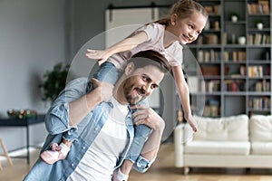 Young father playing with preschooler daughter at home