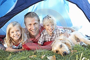 Young father poses with children in tent