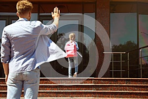 Young father seeing his little child off to school