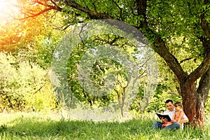 Young father with a small daughter reading the Bible