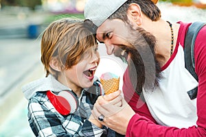 Young father and son enjoying icecream and having fun together. Happy emotional family outdoors. Vacation, summer time, walking at