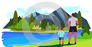 young father and son fishing with rods on lake parenting fatherhood concept dad spending time with kid