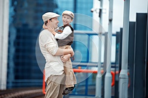 Young father and son on railway station platform