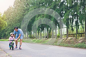 Young father spend time with Cute little Asian 2 years old toddler boy child, Dad and son having fun with balance bike run bike