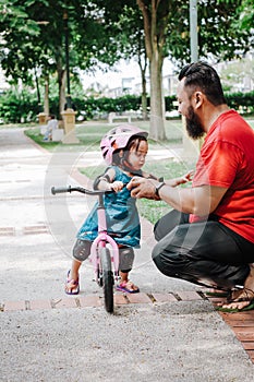 Young father spend time with Cute little Asian 2 years old toddler girl child, Dad and child having fun with balance bike run