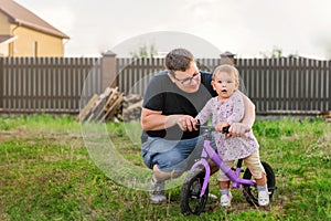 Young father spend time with Cute little one years old toddler girl child and balance bike, father`s day