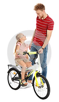 Young father teaching daughter to ride  on white background