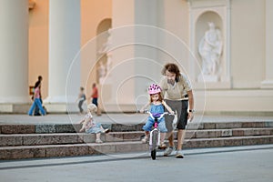 Young father teaching his daughter to ride a bike