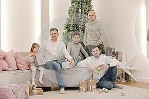 Young father with three sons aand one granddaughter. Big family at Christmas eve