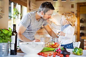 Young father with a toddler boy cooking.