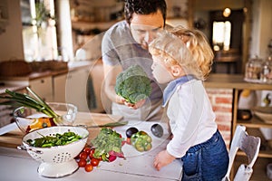 Young father with a toddler boy cooking.