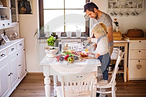 Young father with a toddler boy cooking.