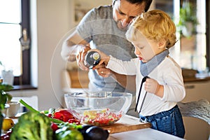 Young father with a toddler boy cooking.