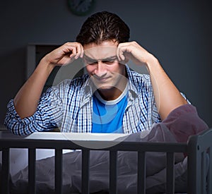 Young father under stress due to baby crying at night