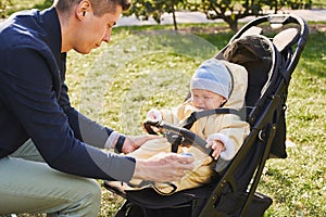 A young father on a walk in an autumn park with a young child son